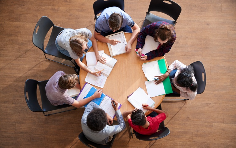 Gruppe personer som jobber sammen rundt et bord