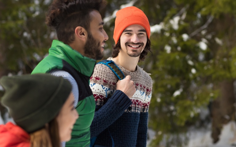 Mann på tur i skogen titter i kamera