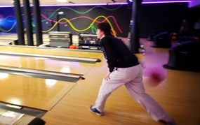 Ung mann i ferd med å kaste en bowlingkule.