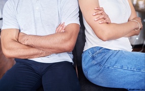 Mann og dame sitter med kryssede armer