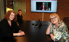 Foto av kollegaer på møterom med storskjerm