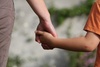 Voksen og barn holder hverandre i hånden
