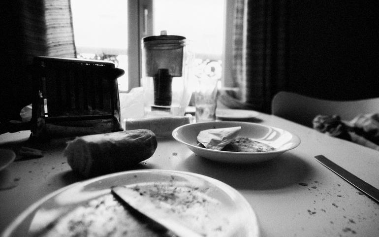 svart hvit foto av frokostrester, kjøkkenbenk og vindu