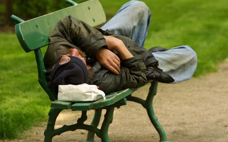 Sovende på benk i parken